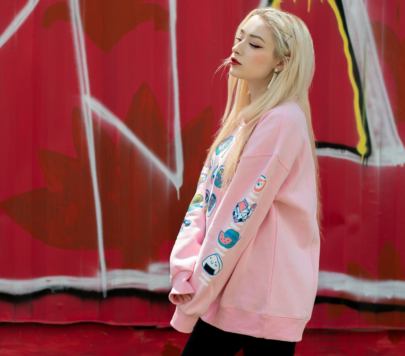 Light pink bento box sweatshirt in an ultra soft exterior jersey fabric with a warm fuzzy interior. Model is displaying left sleeves of the sweatshirt while looking right.